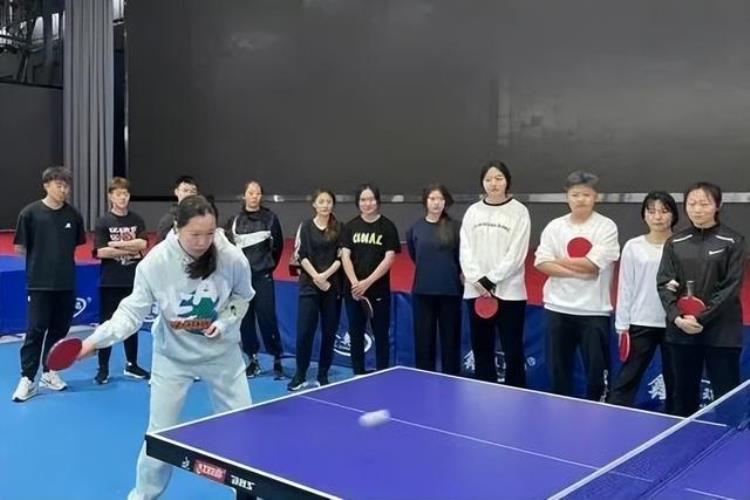 乒乓球大满贯李晓霞做教练拿起球拍教大学生打乒乓球